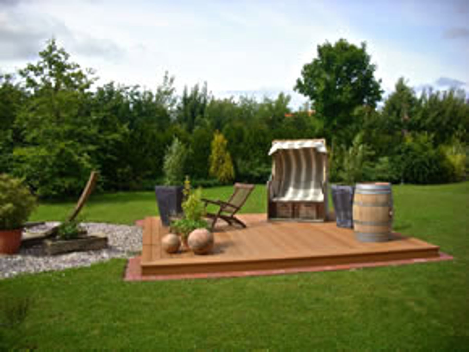 Holzterrasse mit Strandkorb und Rasenfläche